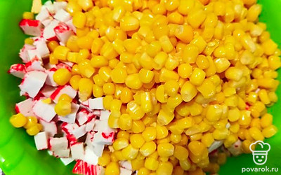 К рису добавить нарезанные яйца, крабовые палочки, огурец и лук, а также кукурузу. Все перемешать и приправить майонезом.