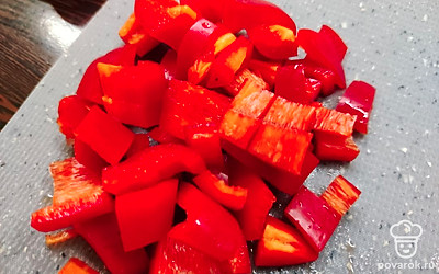 Нарежьте кубиками перец.