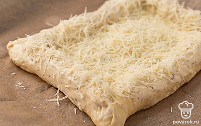 Натрите пармезан на мелкой терке. Посыпьте пармезаном пиццу, включая бортики.