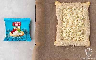 Натрите моцареллу на крупной терке. Выложите тертый сыр внутрь пиццы. Переложите пиццу на противень и отправьте в духовку на 20-25 минут.