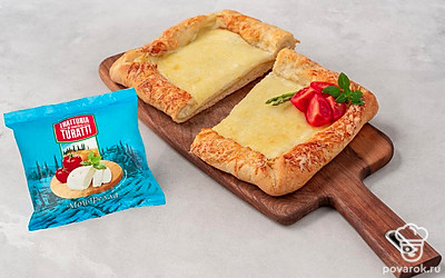 Разорвите мешочек бурраты и положите его в середину пиццы. Вокруг выложите половинки помидоров черри. Полейте все бальзамическим соусом.