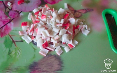 Нарезать крабовые палочки.