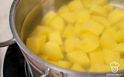 Нарежьте картофель кубиками, переложите в кастрюлю. Залейте его водой и поставьте на огонь. Сварите картофель в течение 20 минут после закипания.