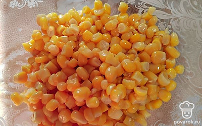 Открываем, сливаем всю воду, высыпаем кукурузу к крабовым палочками. 