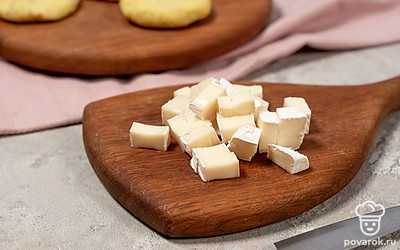 Нарежьте камамбер небольшими кусочками. Возьмите немного картофельного пюре и слепите из него лепешку.