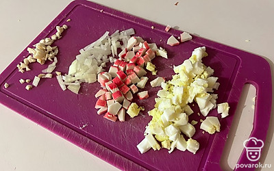 Вареное яйцо, крабовые палочки, лук и чеснок нарежьте мелким кубиком. 