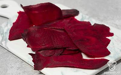 Нарежьте свеклу очень тонкими ломтиками. Можете сделать это просто ножом, слайсером, теркой или кухонным комбайном со специальной насадкой.