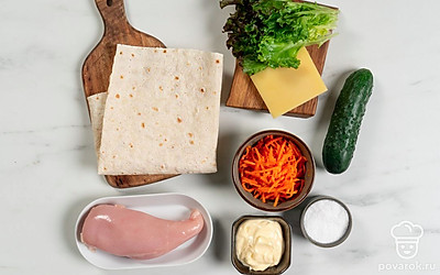 Помойте огурец. Ополосните и хорошо обсушите листья салата. Если вода попадет на тонкий лаваш, он размокнет и рулет развалится. Удалите грубые стебли.