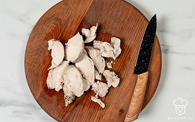 Сварите куриное филе. Нарежьте отварное мясо тонкими ломтиками.