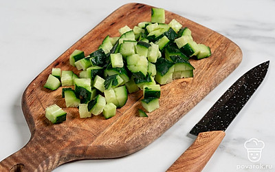 Нарежьте огурец кубиками. Если он водянистый, вырежьте сердцевину с семенами. Кожицу можете срезать или оставить. 