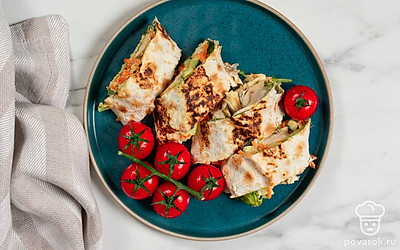 Нарежьте ролл из лаваша на порции. Подайте рулеты со свежими овощами. 