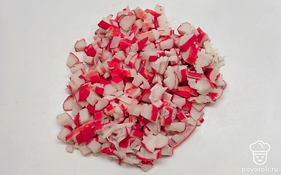 Возьмите большую миску, нарежьте в нее крабовые палочки, сначала вдоль, затем поперек небольшими кусочками. Яйца и огурцы порежьте небольшими кубиками.