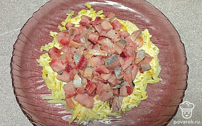 Выложите сверху нарезанное на кусочки филе сельди.