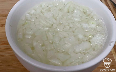 Лук нарежьте кубиком и поместите в теплую воду с уксусом на 30 минут.