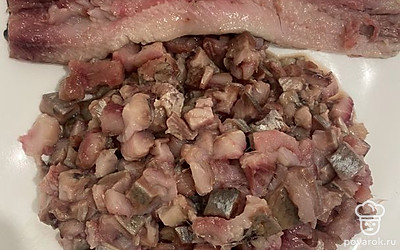 Очистите сельдь от костей и нарежьте мелкими кусочками.