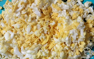 Натрите на терке вареные яйца.