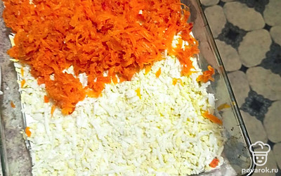 Далее слой натертых яиц и отварной моркови. Подсаливаем.