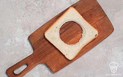 Вырежьте в ломтике хлеба отверстие в виде сердца или круга при помощи формочки для печенья, стакана или ножа.