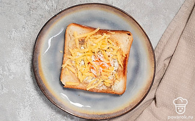 Перед подачей посыпьте хлеб с яйцом тертым сыром.