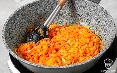 Мелко нарежьте лук, натрите на крупной терке морковь. Налейте в сковороду подсолнечное масло, разогрейте на огне выше среднего. Опустите в масло лук, прожарьте его до легкого румяного оттенка. Добавьте морковь и обжарьте все вместе, помешивая, 2-3 минуты. 