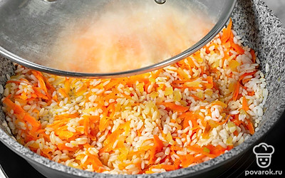 Добавьте к овощам рис и подсушите его, перемешивая, около 2 минут. Налейте в сковороду горячую воду, посолите и поперчите. Убавьте огонь до слабого, накройте сковороду крышкой и готовьте рис около 10 минут. 