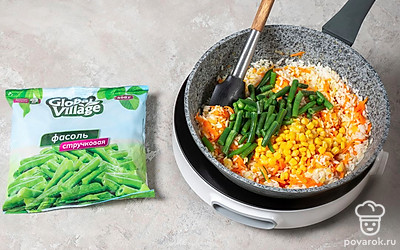 Добавьте к рису стручковую фасоль и кукурузу, прогрейте все вместе 2-3 минуты.