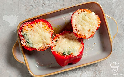 Натрите твердый сыр на средней терке. Достаньте форму с перцами из духовки, снимите с них «шляпки» и присыпьте начинку тертым сыром. Запекайте перцы еще 5 минут, чтобы сыр расплавился. Слегка остудите готовые перцы, прикройте «крышечками» из верхней части и подавайте к столу.