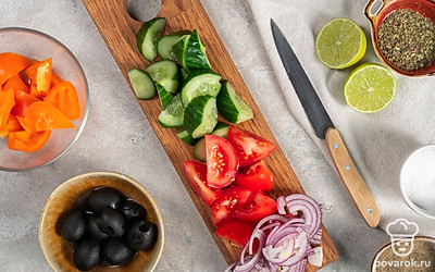Подготовьте остальные ингредиенты для салата. Порежьте огурцы, помидоры и перец на крупные ломтики, луковицу — на полукольца, а сыр фета — на кубики.