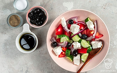 Приготовьте салат. Соедините в салатнице нарезанные перец, огурцы, помидоры, лук и маслины. Посолите, поперчите, полейте заправкой и перемешайте. Сверху выложите нарезанную фету.