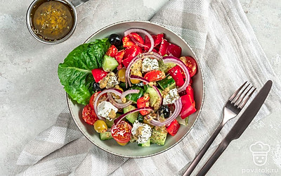 При подаче на дно тарелки положите листья салата и выложите на них греческий салат.