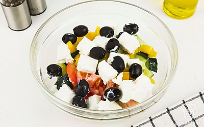 Все овощи порежьте на средние кубики размером 1 – 1,5 см. Постарайтесь нарезать ингредиенты так, чтобы они совпадали по размеру. Сложите все в глубокую емкость, добавьте сыр «Фета» и маслины.