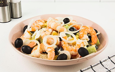 Приступайте к сборке салата: в отдельную тарелку выложите салат, сверху положите целиковые креветки и кольца репчатого лука. Салат готов!