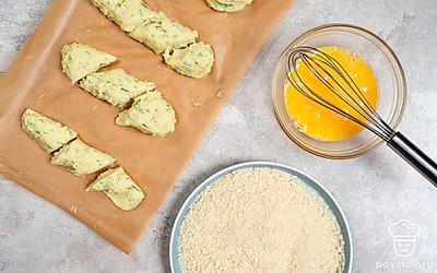 Разрежьте полоски на небольшие кусочки. Разбейте яйца в небольшую миску. Взбейте их венчиком или вилкой. Насыпьте панировочные сухари на другую тарелку.