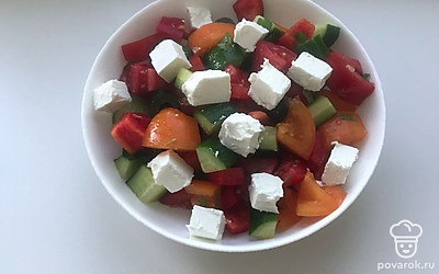 Выложите салат на блюдо и сверху положите нарезанную кубиками фетаксу.