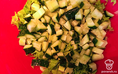 Огурец нарежьте кубиками и высыпьте в салатник.