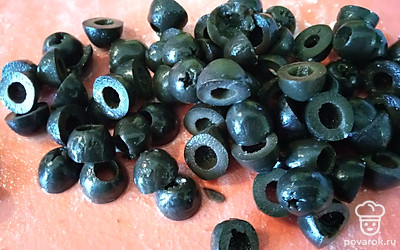 Воду из банки с оливками слейте, разрежьте каждую поперёк на две половинки.