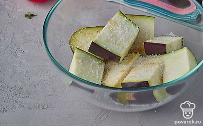 Нарежьте баклажан крупными кусками, положите в глубокую миску и присыпьте солью. Оставьте на полчаса. Это позволит уйти лишней влаге из баклажана.