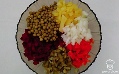 Репчатый лук и соленый огурец нарежьте мелким кубиком, добавьте в салатник. Зеленый консервированный горошек также добавьте в салатник.