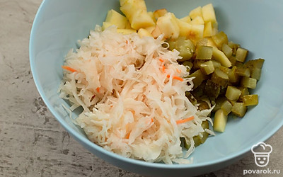 Картофель, свеклу, морковь, огурцы и яблоко, нарезанные ломтиками, кубиками или соломкой, выложите в миску и добавьте квашеную капусту.