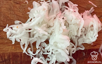 Нашинкуйте произвольно квашеную капусту.