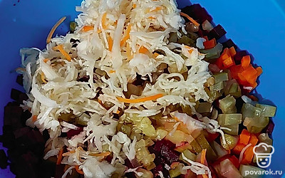 Введите нарезанные огурцы и отжатую от сока капусту.