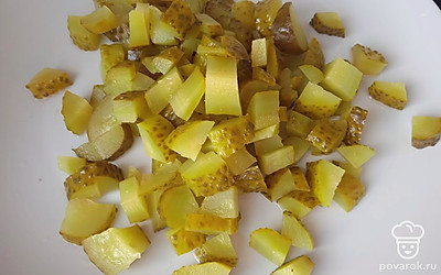 Добавьте нарезанные кубиками маринованные огурцы.