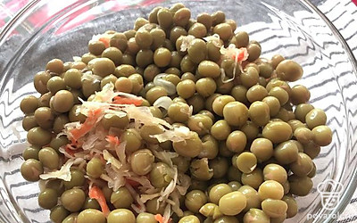 Капусту дважды промойте чистой водой, отожмите и выложите в миску. С горошка слейте жидкость и добавьте к капусте.