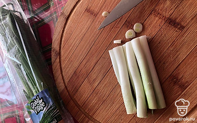 Нам понадобятся черенки лука. Они дают крепкий вкус и аромат. Помойте, нарежьте.