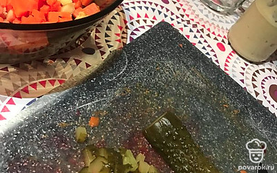 В последнюю очередь положите маринованные или соленые огурчики, тоже порезанные до размера горошка.