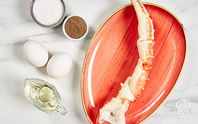 Разморозьте, промойте и обсушите краба, срежьте крайние заостренные фаланги. Надрежьте панцири на остальных фалангах клешни и достаньте крабовое мясо, стараясь его не повредить. Вымойте яйца, отделите белки от желтков в удобную для взбивания миску. Подготовьте венчик, сковороду и сервировочное блюдо.