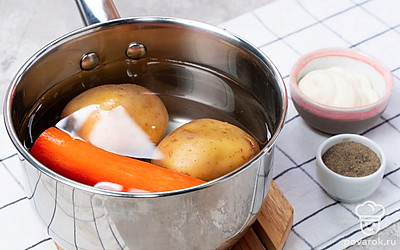 Подготовьте ингредиенты для салата. Отварите картофель и морковь в течение 15-30 минут, в зависимости от размера овощей. Затем остудите их, почистите и отдельно натрите на мелкой терке. Раскалите на сковороде масло и выложите шампиньоны, обжарьте их 10 минут. Затем добавьте лук, посолите, поперчите и жарьте еще 5 минут.