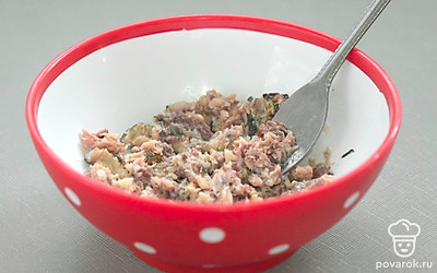 Кусочки консервированной рыбы выложите без масла в миску и разомните вилкой.