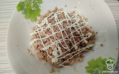 На дно салатника выложите половину лука и половину горбуши. Сделайте майонезную сеточку. 