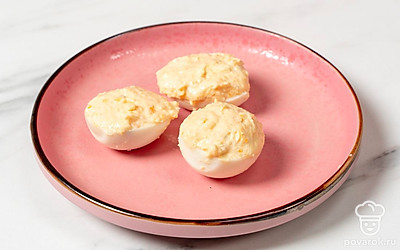 Разложите готовую начинку по яичным белкам при помощи ложки. 